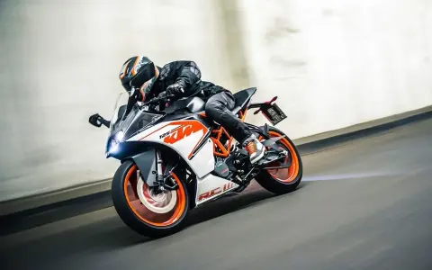 Motocyklista w kasku śmiga na KTM RC 125, osiągając maksymalną prędkość na torze.
