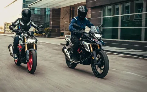 Dwóch motocyklistów na motocyklach BMW G ściga się po mieście.