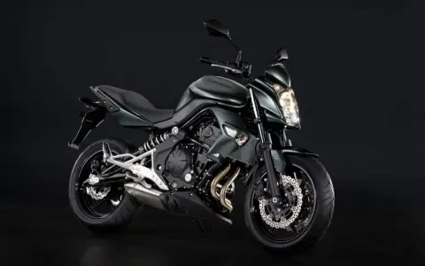Zielony motocykl Kawasaki ER6N z ciemnym tłem.