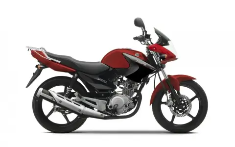 Czerwony motocykl Yamaha YBR 125, z czarnymi akcentami i bagażnikiem. Wady tego modelu to m.in. brak wskaźnika paliwa.