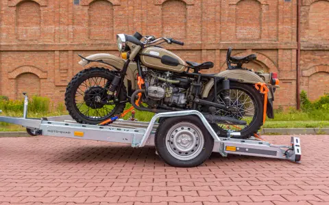 Jak przewieźć motocykl na zwykłej przyczepie? Oto przykład z użyciem pasów transportowych do zabezpieczenia ciężkiego motocykla.