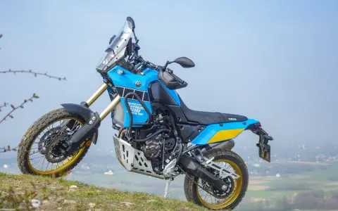 Niebiesko-żółty motocykl Yamaha Tenere 700 Rally gotowy na przygodę na wzgórzu.