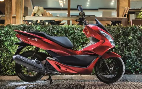 Lśniący czerwony skuter 125, idealny na 15 km dojazdy do pracy. Elegancki design i komfortowa jazda.
