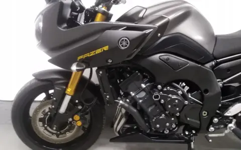 Ciemnoszary motocykl Yamaha FZ8 z żółtym napisem "FAZER" na baku. Widoczny fragment przedniego koła, zawieszenia i silnika.