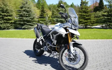 Biały motocykl Triumph Tiger 900 na brukowanej nawierzchni. Poznaj jego imponujące triumph tiger 900 dane techniczne.