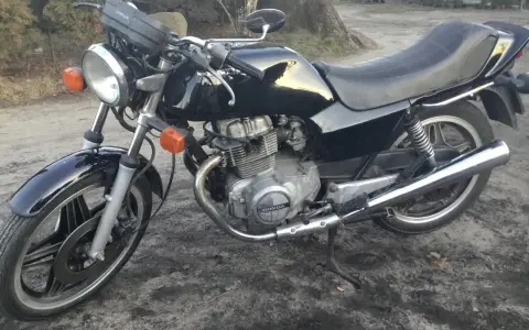 Czarny motocykl Honda CB250T z lat 80. stoi na ziemi.