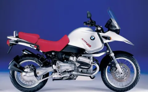 Srebrny motocykl BMW R 1150 GS z czerwoną kanapą, gotowy na przygodę.