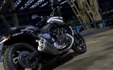 Potężny motocykl Yamaha V-Max 1700 z chromowanymi elementami, stojący w industrialnym wnętrzu.