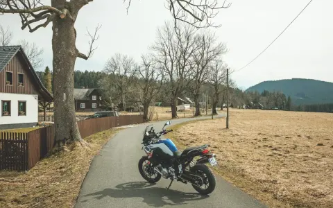 Motocykl czeka na przygodę na malowniczej drodze. Idealne miejsce na odkrywanie tras motocyklowych w Czechach.