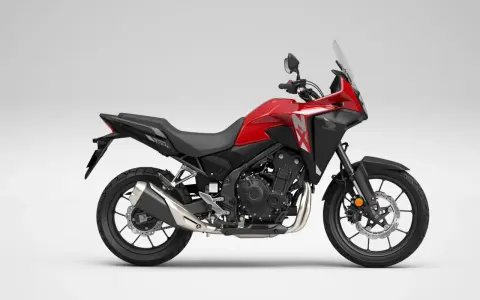 Czerwony motocykl Honda NX 500 z czarnymi elementami, gotowy na przygodę.