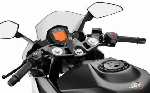 Widok na kierownicę motocykla KTM z cyfrowym wyświetlaczem, lusterkami i uchwytem.