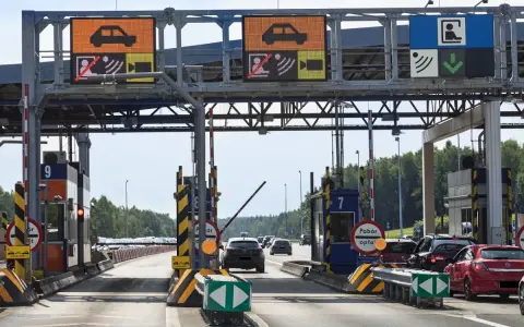 Pobieranie opłat na autostradzie A4. Samochody zbliżają się do bramek, na których wyświetlane są informacje o opłatach.