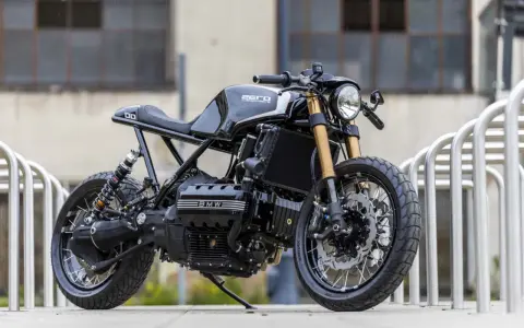 Czarny motocykl BMW K100 w stylu cafe racer, stojący na zewnątrz.