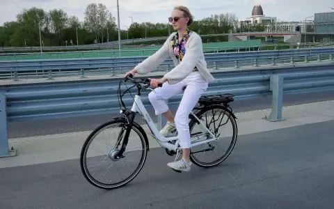 Młoda kobieta na rowerze elektrycznym, zastanawia się, czy na rower elektryczny trzeba mieć prawo jazdy.
