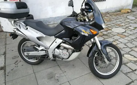 Czarny motocykl Aprilia Pegaso 650 z kufrem na bagaż, gotowy na przygodę.