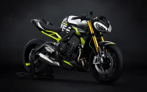 Nowoczesny motocykl Triumph Street Triple w białym i czarnym malowaniu z neonowo-żółtymi akcentami, gotowy do drogi.