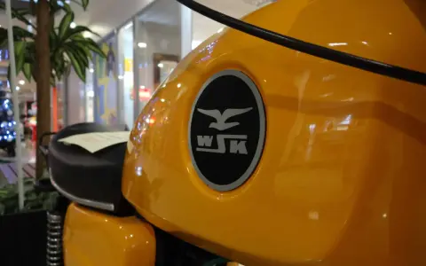 Żółty bak motocykla WSK z charakterystycznym logo. Czy jego prędkość maksymalna to 125 km/h?