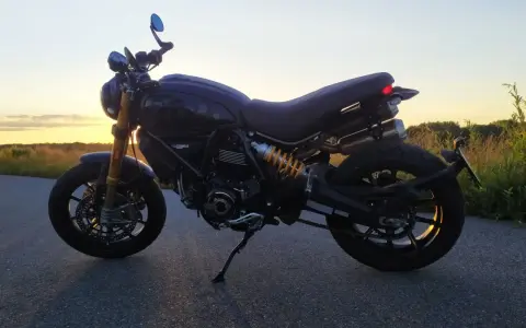 Czarny Ducati Scrambler 1100 na tle zachodzącego słońca. Idealny na wieczorną przejażdżkę.