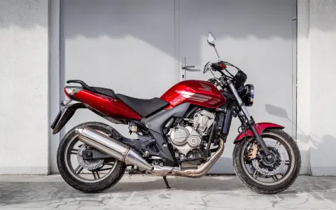 Czerwony motorower Honda Hornet, idealny do miasta. Zastanawiasz się, ile kosztuje motorower tej klasy?