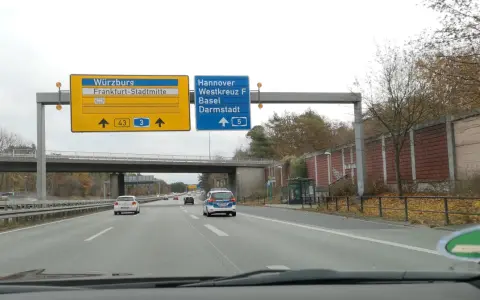 Autostrada A5. Znaki kierują do Würzburga, Frankfurtu, Hanoweru i Darmstadt. Na drodze ruch samochodowy.