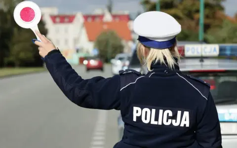 Policjantka z tarczą zatrzymuje ruch. Kierowca, który już raz dostał mandat, musi uważać, by nie popełnić kolejnego wykroczenia.
