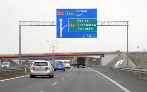 Autostradą A2 w kierunku Poznania i Łodzi. Znak informuje o minimalnej prędkości na autostradzie i zjeździe na Grójec, Sochaczew, Żyrardów za 500 m.