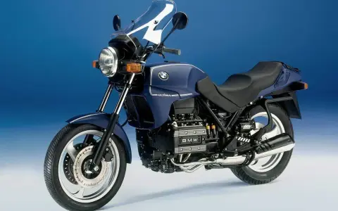 Granatowy motocykl BMW K75 z owiewką i widocznym silnikiem. Szczegółowe dane techniczne BMW K75 dostępne w sieci.