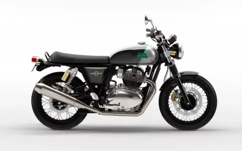 Stylowy Royal Enfield Interceptor 650 w kolorze szaro-zielonym, z chromowanym silnikiem i czarnym, pikowanym siedzeniem, gotowy na każdą podróż.