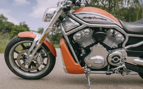 Pomarańczowy Harley-Davidson z serii V-Rod, potężny muscle bike, gotowy na jazdę.