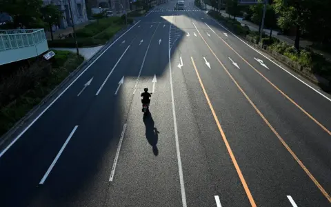 Samotny motocyklista na pustej drodze, cień rzuca się na asfalt. Zastanawia się, jak wyrejestrować skuter.