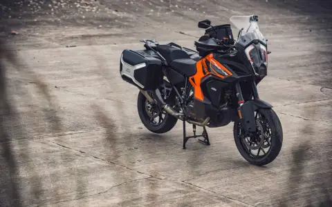 Pomarańczowo-czarny motocykl KTM 1290 Super Adventure z kuframi, gotowy na każdą wyprawę.