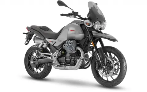 Srebrny motocykl Moto Guzzi V85 TT z charakterystycznym silnikiem V-twin, gotowy na przygodę.