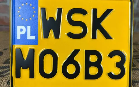 Żółta tablica rejestracyjna z oznaczeniem PL i numerem WSK M06B3.