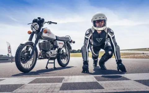 Motocykl MZ ETZ 250 i zawodnik w kombinezonie i kasku na starcie wyścigu. Gotowi do startu!