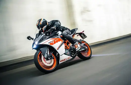 Motocyklista w kasku śmiga na KTM RC 125, osiągając maksymalną prędkość na torze.