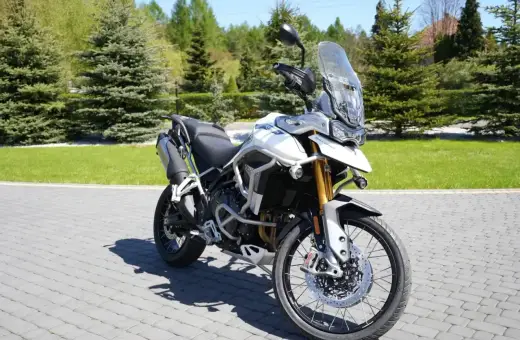 Biały motocykl Triumph Tiger 900 na brukowanej nawierzchni. Poznaj jego imponujące triumph tiger 900 dane techniczne.