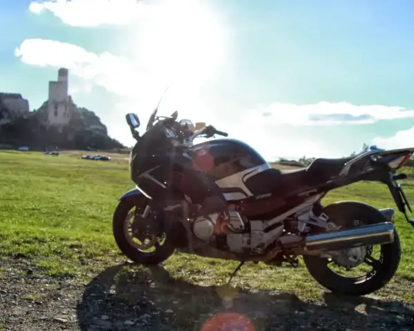 Motocykl na tle zamku w skale. Idealny kompan na podróż po Jurze Krakowsko-Częstochowskiej.