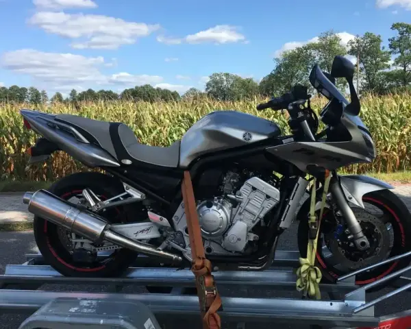 Srebrny motocykl Yamaha Fazer na przyczepce. Zastanawiasz się, ile kosztuje motocykl? Ten model to świetna opcja.