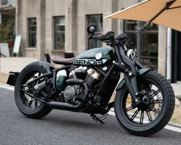 Stylowy, zielony motocykl typu cruiser z brązowym siedzeniem. Idealny do miejskich podróży, mógłby znaleźć się w rankingu motocykli cruiser.
