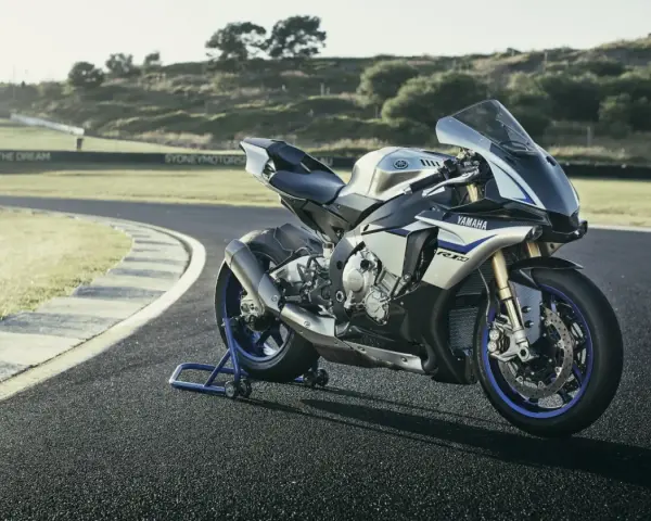 Srebrno-niebieski motocykl Yamaha R1M na torze wyścigowym, gotowy do jazdy.