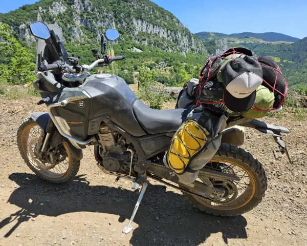 Motocykl Kove 800X Rally gotowy na przygodę, z bagażem na wyprawę po górskich drogach.