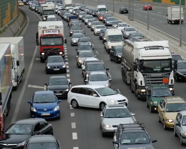 Korki na autostradzie, wiele samochodów i ciężarówek stoi w miejscu. Aktualne utrudnienia na drogach uniemożliwiają płynny ruch.