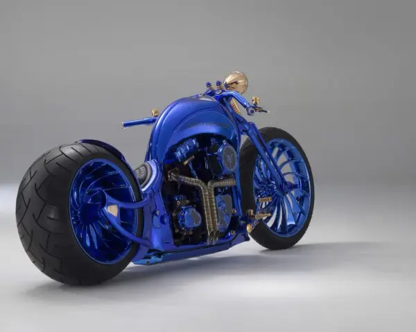 Błyszczący, niebieski Harley-Davidson, prawdopodobnie najdroższy motor na świecie, z masywnymi kołami i złotymi detalami.