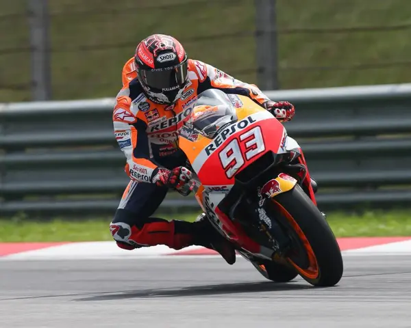 Motocyklista w kombinezonie Repsol Honda z numerem 93 wykonuje ostry zakręt, stosując technikę przeciwskrętu.