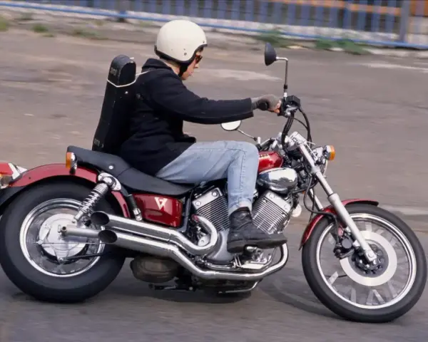Motocyklista na czerwonym Yamaha Virago 535, z futerałem na instrumenty z tyłu. Dane techniczne tego modelu są imponujące.
