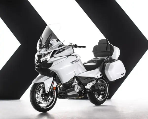 Biały, luksusowy motocykl turystyczny z kuframi, gotowy na dalekie podróże. Chińskie motocykle turystyczne oferują komfort i styl.