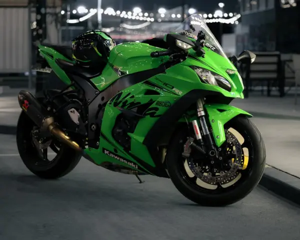 Japoński motocykl Kawasaki Ninja ZX-10R w jaskrawym zielonym kolorze, gotowy do nocnej jazdy.