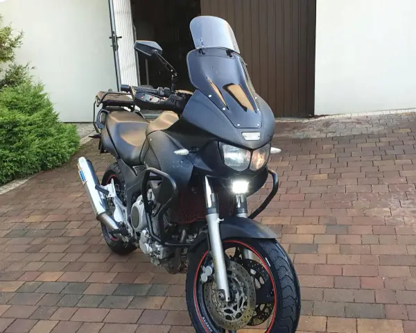 Czarny motocykl Yamaha TDM 850 z turystyczną owiewką i dodatkowymi światłami LED, gotowy na przygodę.