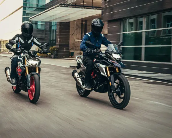 Dwóch motocyklistów na motocyklach BMW G ściga się po mieście.
