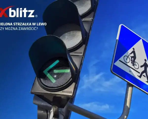 Sygnalizacja świetlna strzałki w lewo świeci na zielono. Obok znak drogi dla rowerzystów i pieszych.